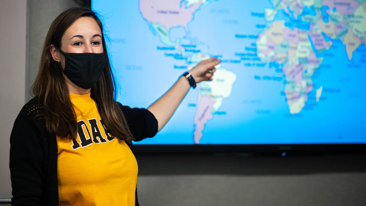 Woman points toward computer image of a map