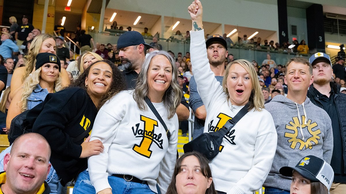 A group of students and fans at a Vandals football game cheering