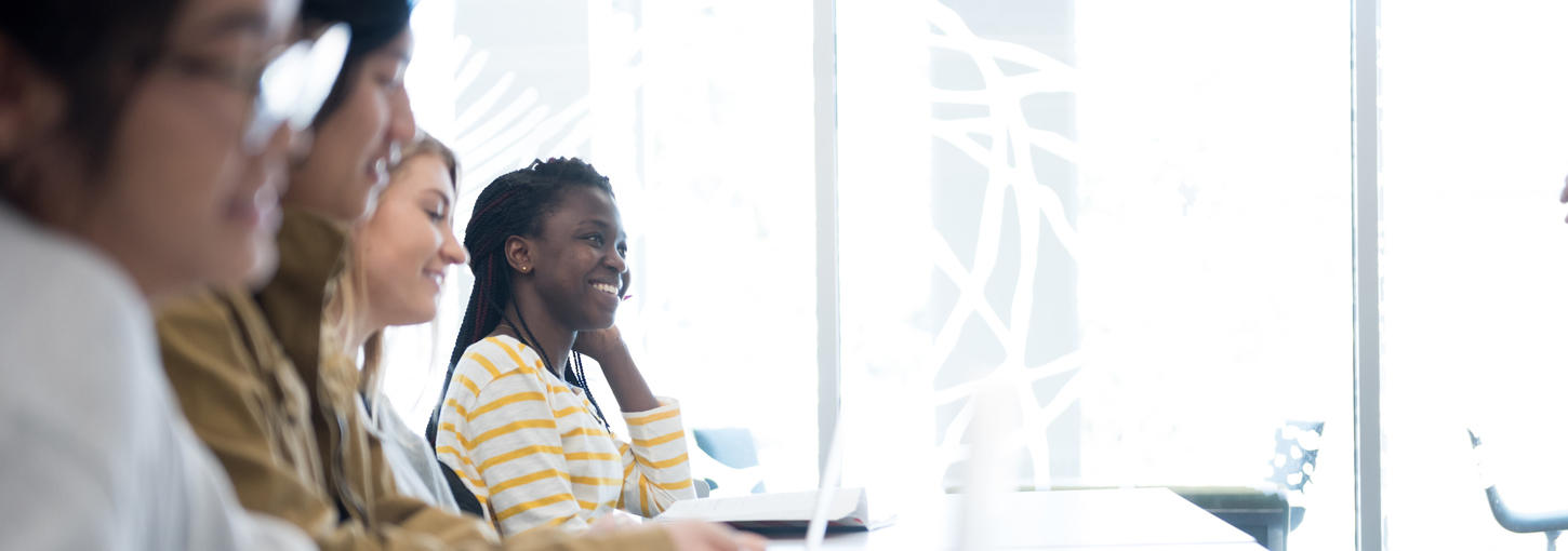 Students sit at desks in a classroom.